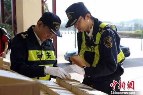 资料图：深圳海关关员正在查验假冒“小米”手机。 深圳海关供图