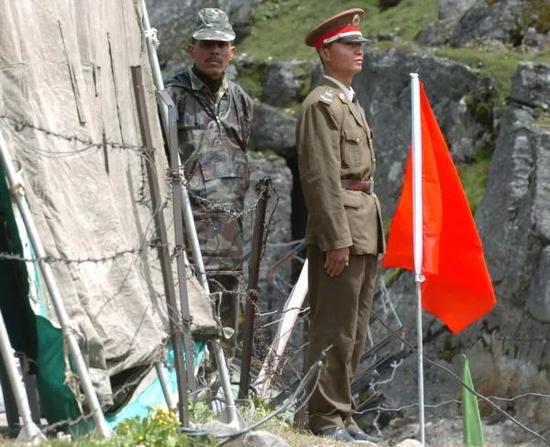 ▲资料图片：在中印边境乃堆拉山口，一名中国边防军人（右）与一名印度边防军人隔着边界的铁丝网值勤。