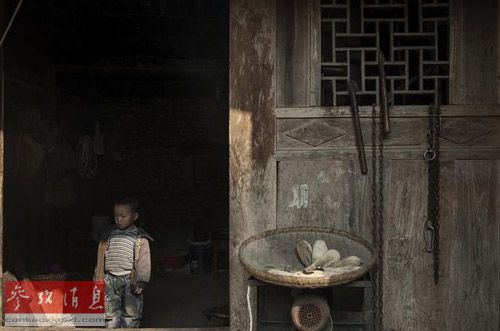 资料图片：贵州一名留守儿童孤单地站在家门口。