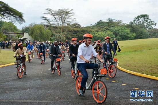 3月5日，首批100辆摩拜单车在联合国位于肯尼亚首都内罗毕的办事处投入使用，联合国环境署执行主任索尔海姆（前）与工作人员体验摩拜单车。新华社记者金正摄