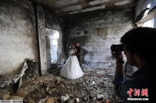 叙利亚霍姆斯一对新婚夫妇以饱受战争蹂躏被毁的建筑为背景拍摄了婚纱照。