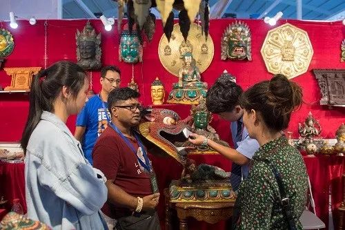 ▲来自尼泊尔的客商（左三）在第5届中国-南亚博览会上出售特色手工艺品。