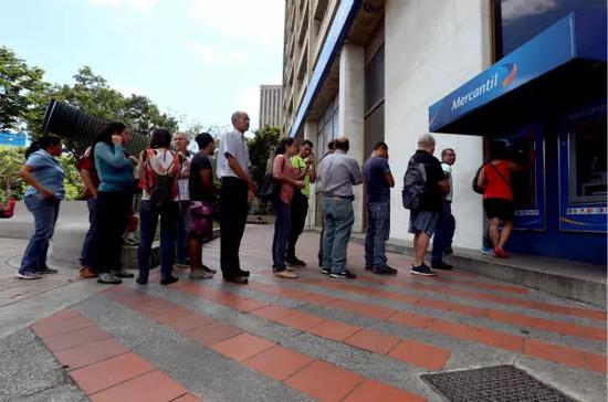 8月20日，在委内瑞拉首都加拉加斯，人们在ATM机前排队取钱。新华社发（格雷戈里奥·特兰摄）