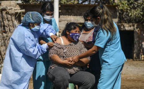 Health workers inoculate a woman with a dose of the Pfizer-BioNTech vaccine against COVID-19, in Arequipa, southern Peru, on 2 July 2021. Picture: Diego Ramos/AFP