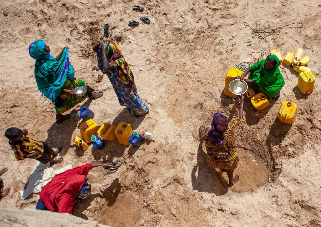 Somali women taking drinking water from a well hole.